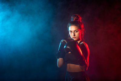 Portrait of beautiful young woman against black background