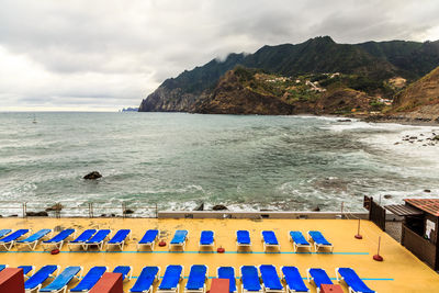 Swimming pool by sea against sky