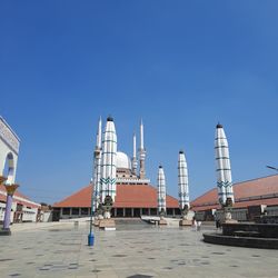 View of buildings in city against clear blue sky