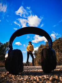 Woman standing on road seen through headphones