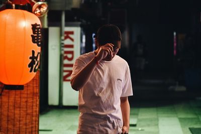 Man photographing with mobile phone standing in city