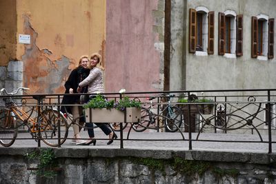 Full length portrait of cheerful friends standing in city