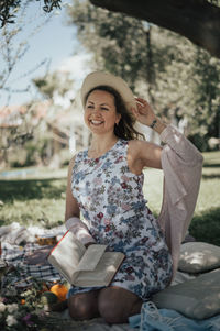 Smiling woman portrait outdoor, picnic with book
