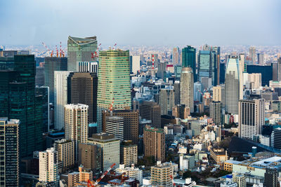 Aerial view of buildings in city against sky