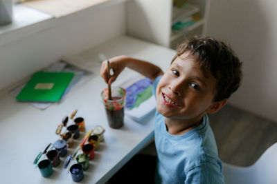 High angle portrait of boy painting at home