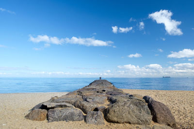 Groyne at brighton beach leading towards sea against sky