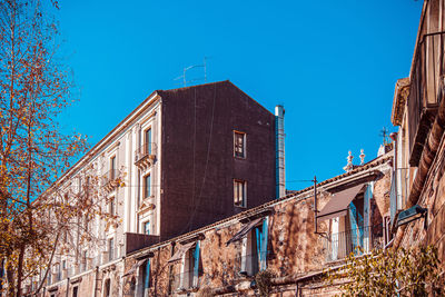 Low angle view of buildings against clear blue sky