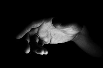 Close-up of hands against black background