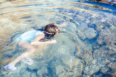 High angle view of boy swimming in pool