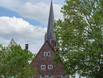 Low angle view of trees and buildings against sky