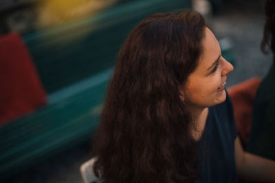 High angle view of smiling young woman looking away during dinner party in backyard