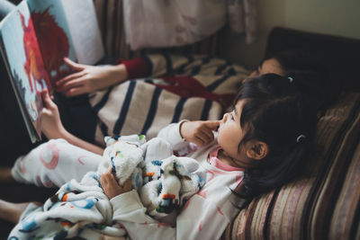 Siblings reading story book at home