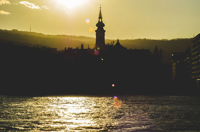 Silhouette of buildings against sky during sunset