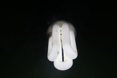 Close-up of illuminated light bulb against black background