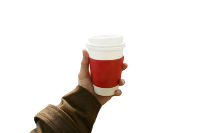 Close-up of hand holding coffee against white background