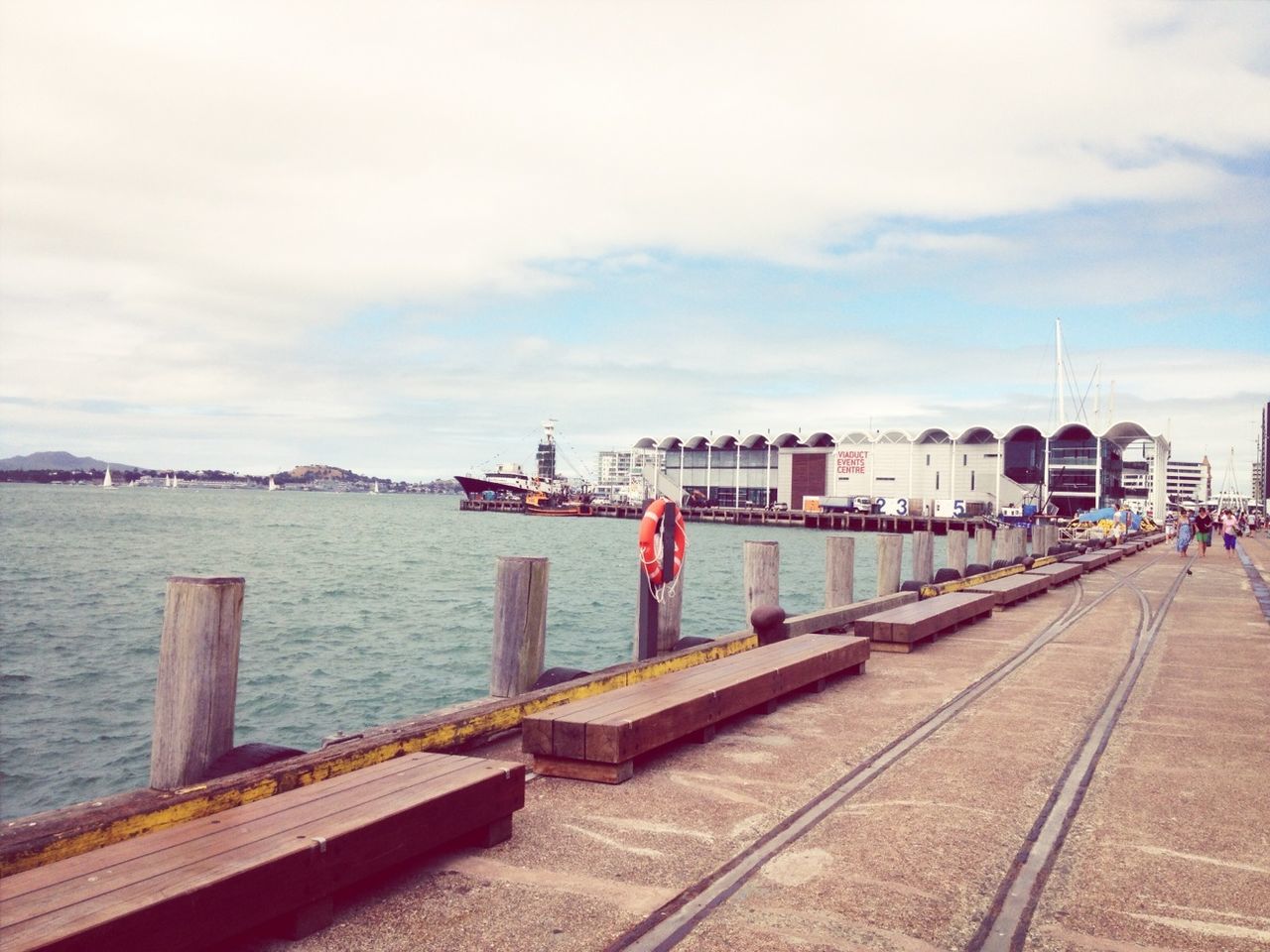 built structure, sky, architecture, water, railing, building exterior, the way forward, transportation, cloud - sky, pier, river, city, day, cloud, sea, incidental people, diminishing perspective, cloudy, outdoors, connection