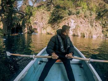 Man standing on railing by river