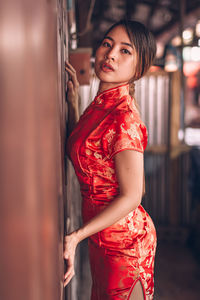 Young woman in traditional clothing against door