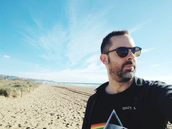 Portrait of young man wearing sunglasses against sky