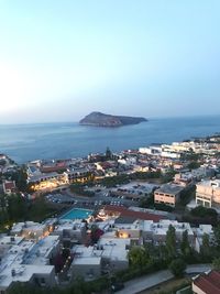 High angle view of townscape by sea against sky
