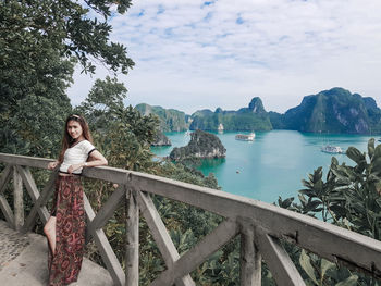 Portrait of young woman leaning on railing