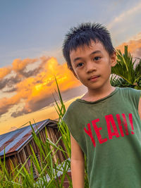 Portrait of boy standing against sky