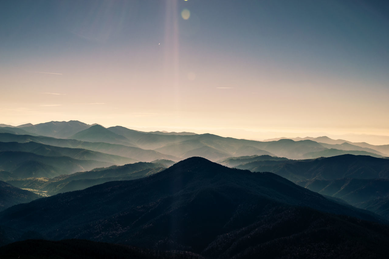 mountain, scenics - nature, beauty in nature, sky, mountain range, tranquil scene, tranquility, environment, landscape, sunset, non-urban scene, idyllic, nature, no people, majestic, silhouette, remote, physical geography, cloud - sky, sun, outdoors, mountain peak, dramatic landscape, mountain ridge