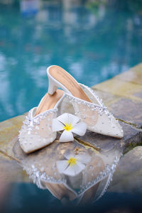 A pair of bride's shoes by the pool