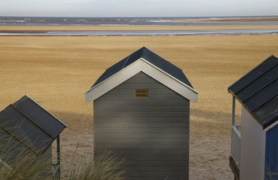 Built structure on beach by sea against sky