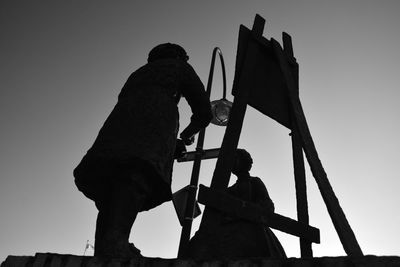 Low angle view of silhouette people against sky