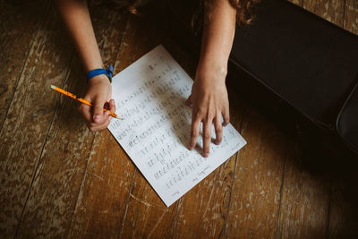 High angle view of woman reading book on table