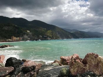 Scenic view of sea and mountains against sky
