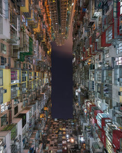 Low angle view of illuminated buildings against sky in city at night