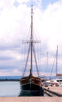 Sailboats moored in sea against sky