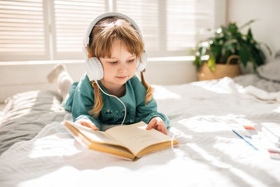 Boy with book on bed