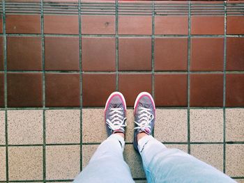 Low section of person standing on tiled floor