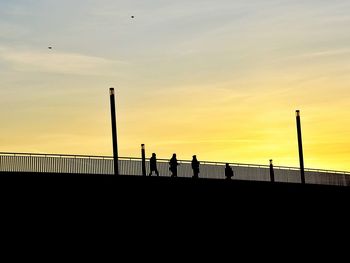 Low angle view of railing against sky at sunset