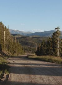 Road leading towards mountains against sky