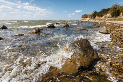 Rocks in sea against sky