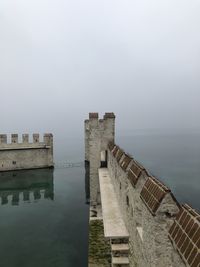 Castle by sea against sky