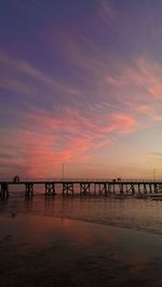 Pier on sea at sunset