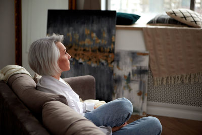 Serene mature woman chilling on couch in living room