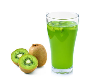 Green fruits in glass against white background