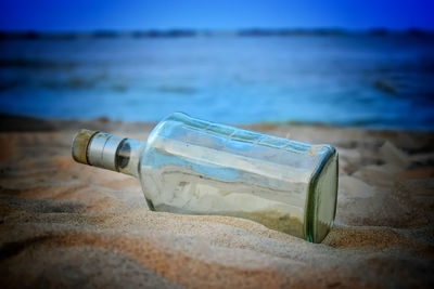 Close-up of bottle on beach