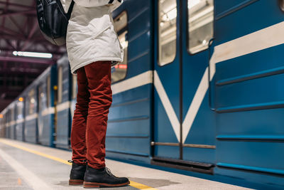 Alone man waiting while subway train open the door. well-dressed handsome male in black boots