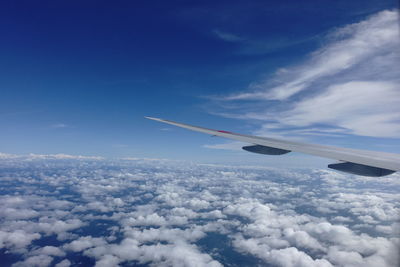 Cropped image of airplane flying over clouds