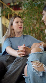 Lesbian couple talking while sitting at home