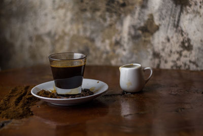 Close-up of coffee cup on table against wall