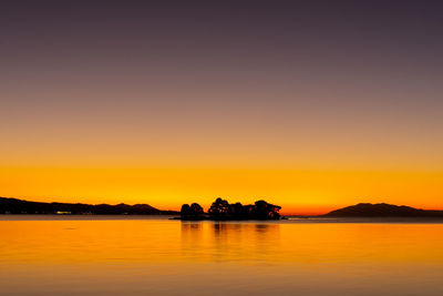 Scenic view of lake against romantic sky at sunset