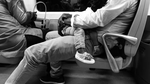 Low section of men sitting in bus